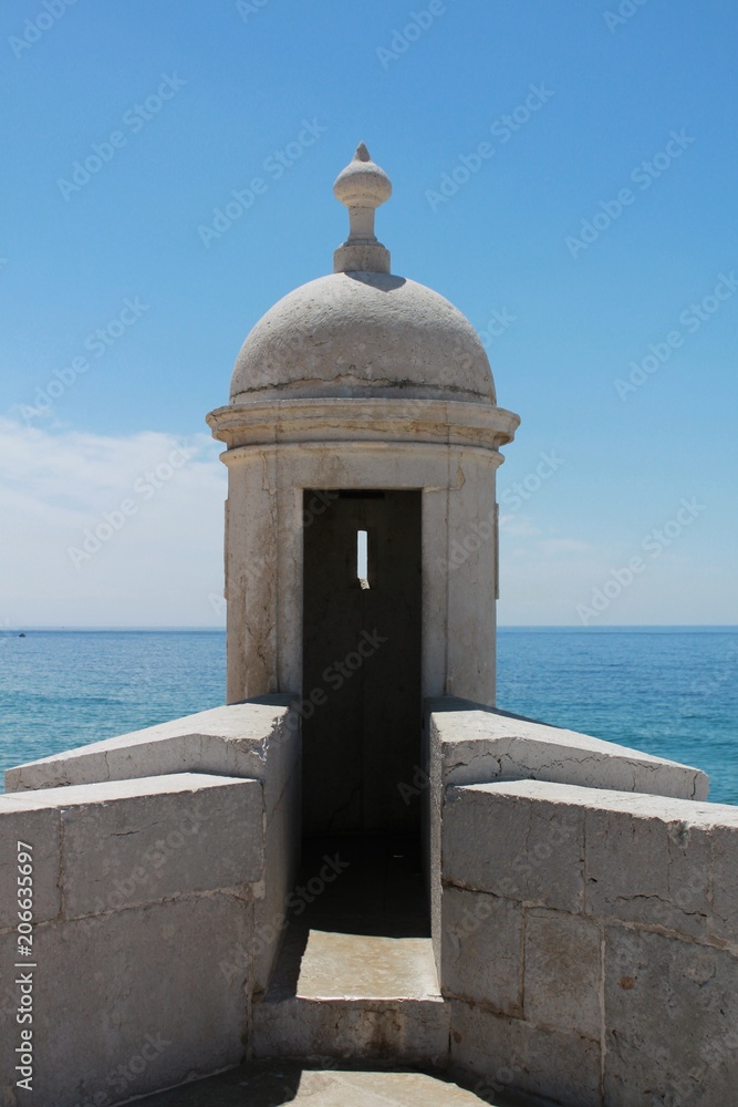Watchtower of the fortress on the beach in Sesimbra village Watchtower of the fortress on the beach in Sesimbra village