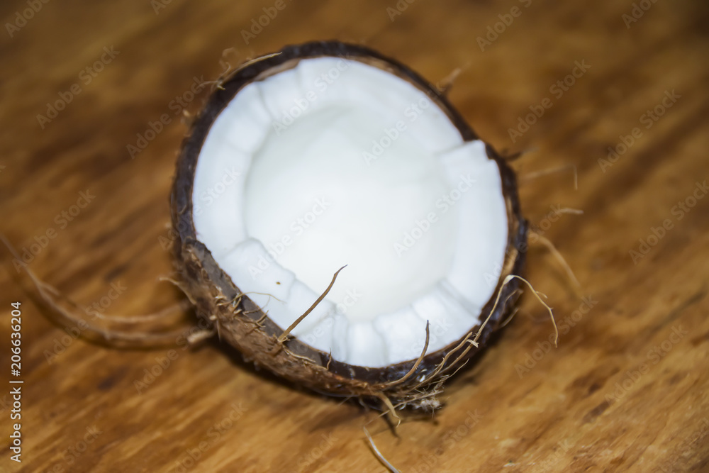 Cracked coconut on a wooden background Cracked coconut on a wooden background