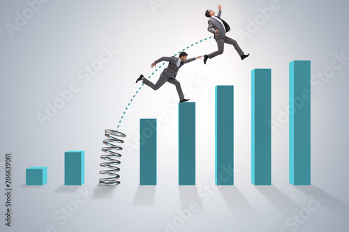 Business people jumping over bar charts