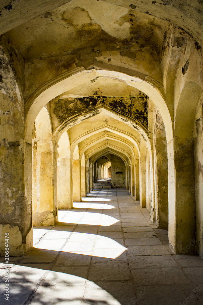 Mughal Arches Creating a Pathway along the Outside of a Tomb Appear Golden in the Sunlight at the Qutb Shahi Tombs in Hyderabad, India