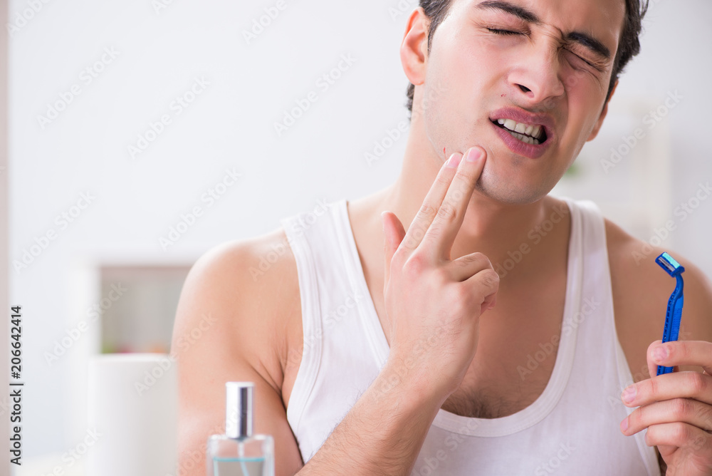Young handsome man shaving early in the morning at home Young handsome man shaving early in the morning at home
