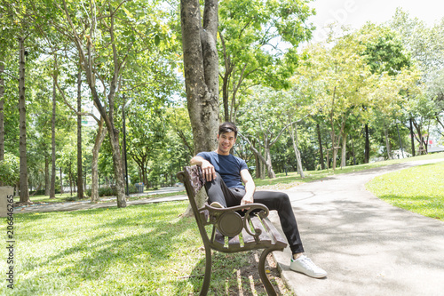 Young man sitting on the chair in the park.