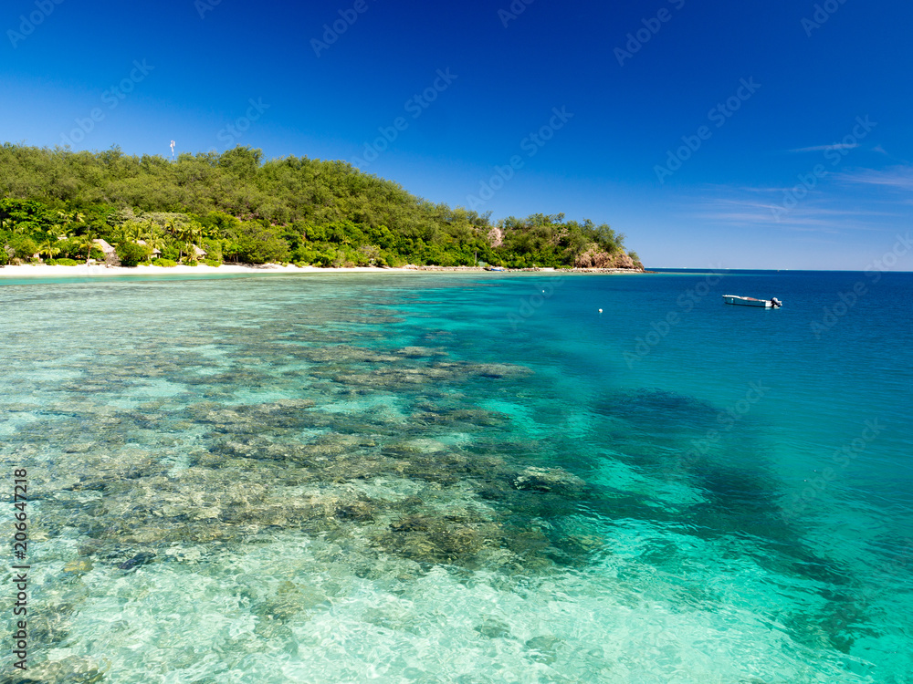 Beautiful Landscape of Reef and Turquoise Aqua Blue Clear Ocean Water with White Sand Beach and Palm Trees on Tropical Pacific Island of Fiji