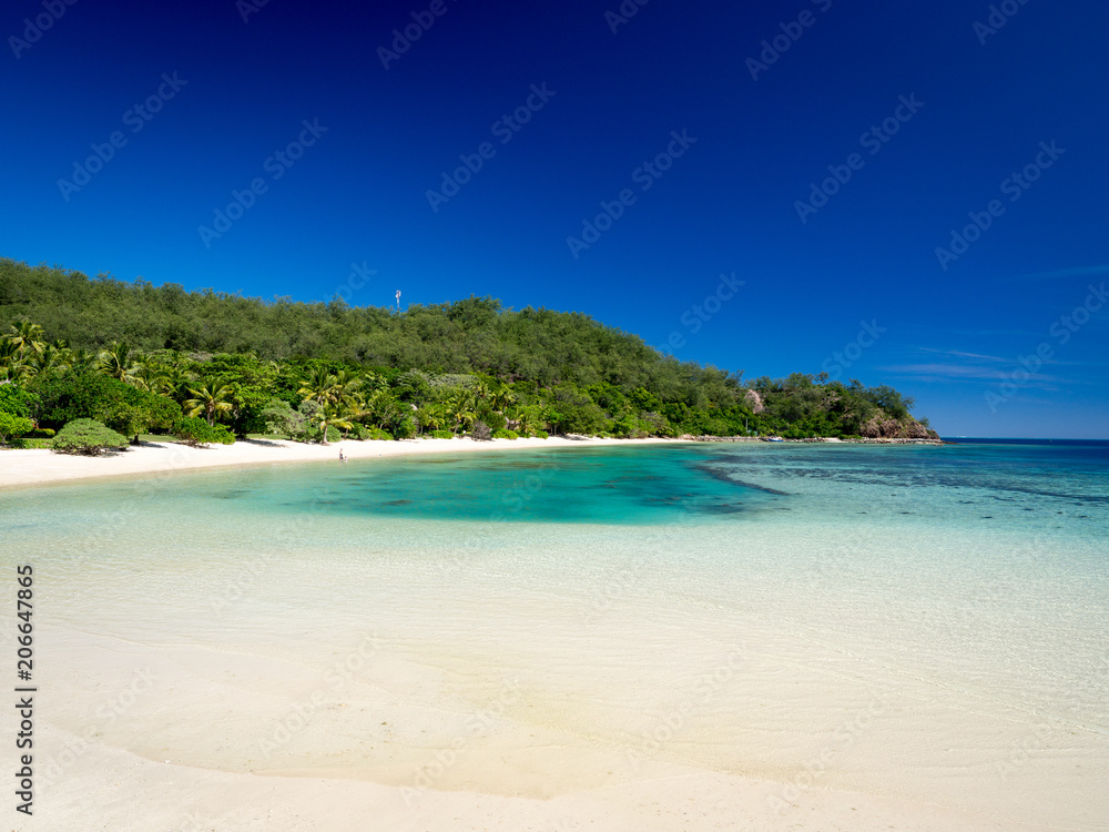 Beautiful Landscape of Reef and Turquoise Aqua Blue Clear Ocean Water with White Sand Beach and Palm Trees on Tropical Pacific Island of Fiji