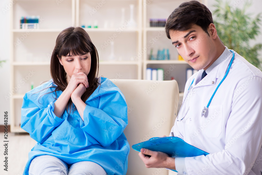 Fototapeta premium Male doctor checking up female patient in hospital