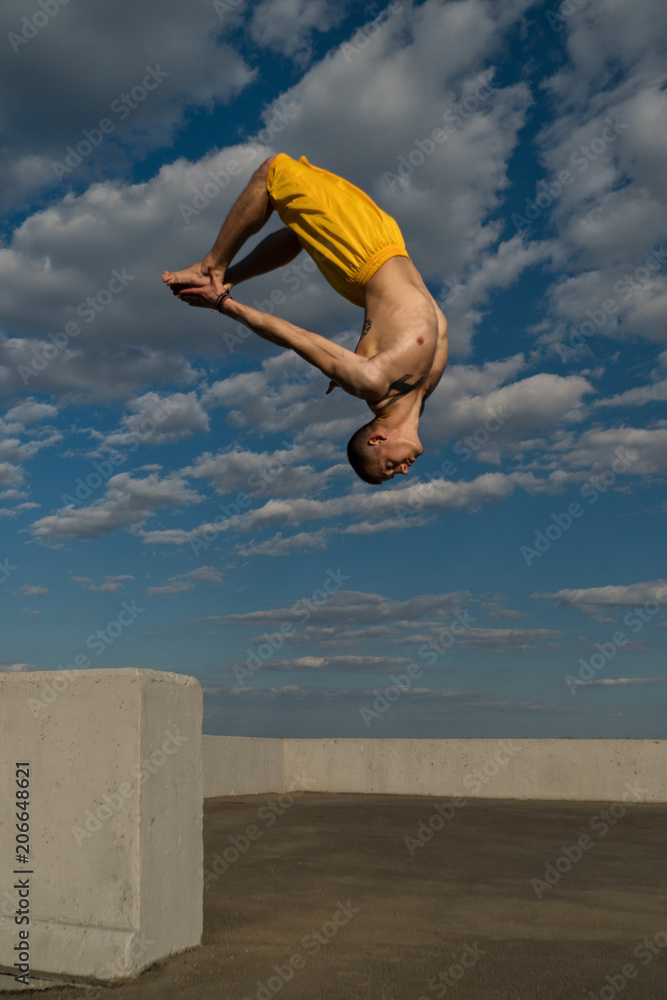 Tricking on street. Martial arts and elements of parkour. Man flips back  barefoot. Taken from low angle against sky. Stock Photo | Adobe Stock