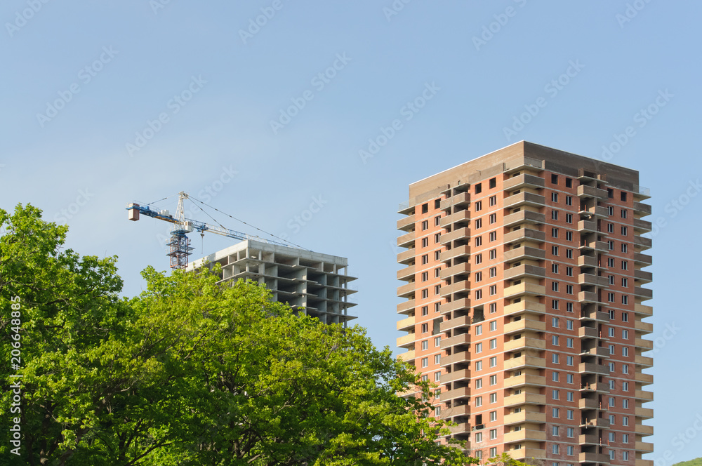 Crane on a construction site at home against a blue sky Crane on a construction site at home against a blue sky
