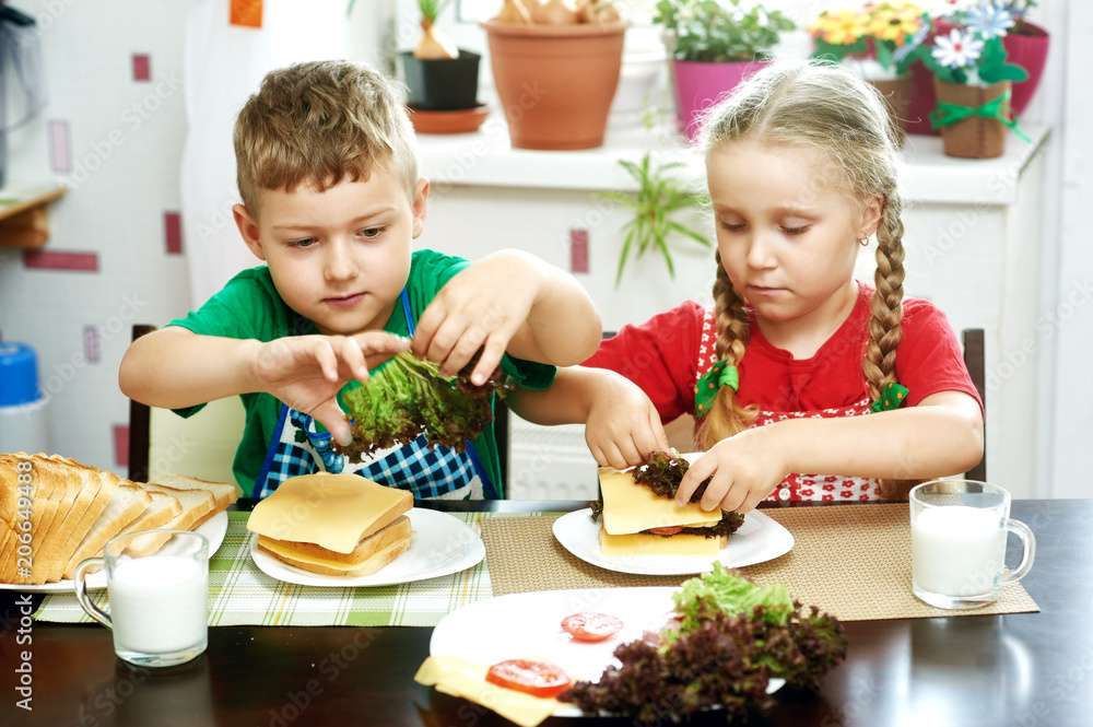 Cheerful children at Breakfast . Brother and sister with sandwiches Cheerful children at Breakfast . Brother and sister with sandwiches