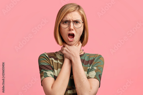 Quadro em tela Portrait of shocked beautiful young female suffers from suffocation or makes sui