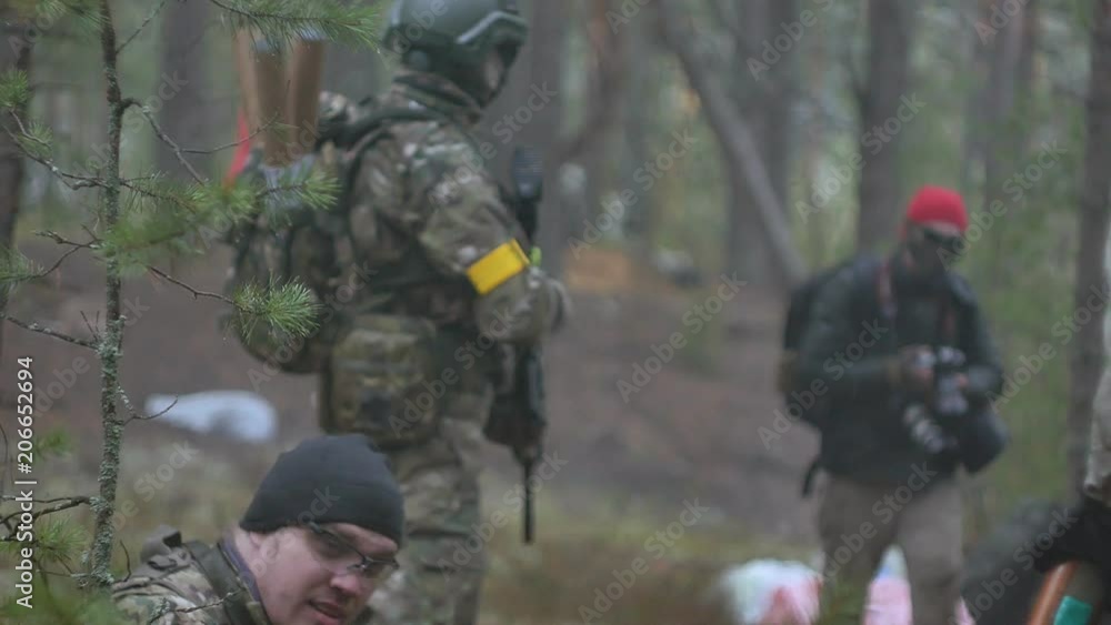 Soldiers in camouflage with combat weapons make their way outside the forest, with the aim of capturing it, the military concept Soldiers in camouflage with combat weapons make their way outside the forest, with the aim of capturing it, the military concept