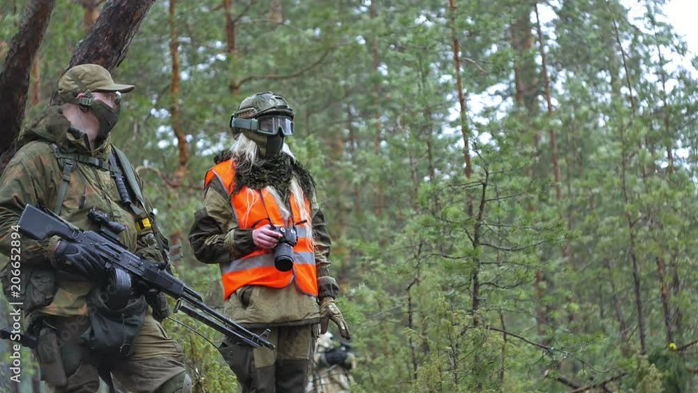 Soldiers in camouflage with combat weapons make their way outside the forest, with the aim of capturing it, the military concept Soldiers in camouflage with combat weapons make their way outside the forest, with the aim of capturing it, the military concept