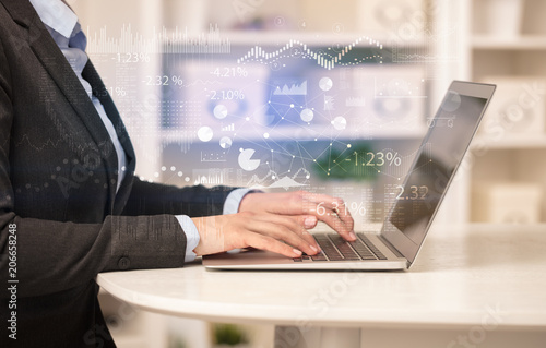 Canvas Print Business woman in homey environment using laptop with financial report concept