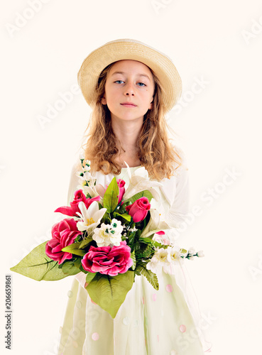blond girl in white dress and straw hat with bouquet of flowers