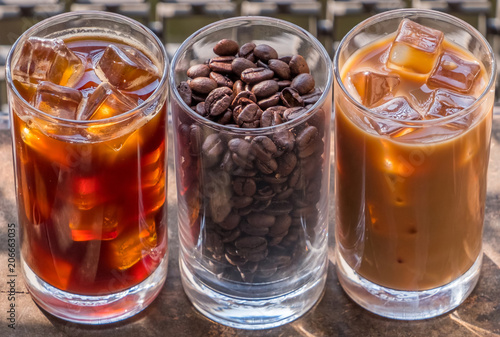 Tablou canvas Black iced coffee, milk coffee, and beans over wooden background