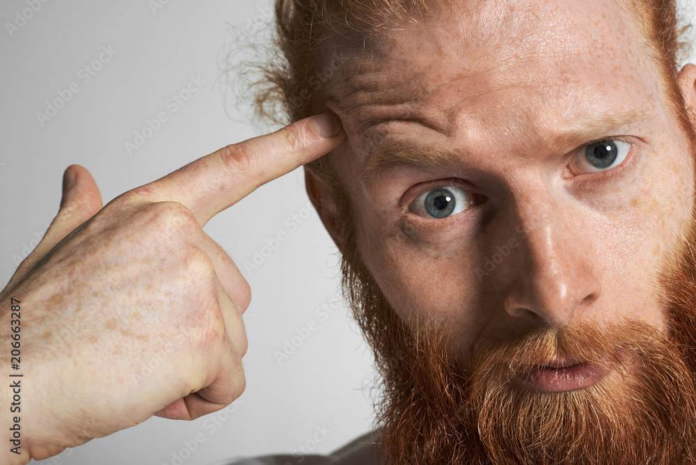 Highly detailed studio portrait of irritated young European macho man