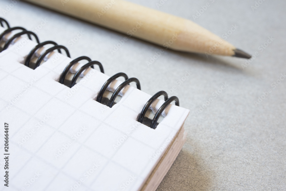Fototapeta premium Notepad and simple pencil, macro photo, business concept, work. close up