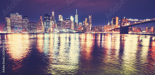 Wide angle view of Manhattan skyline reflected in East River at night  color toned picture  New York City  USA.