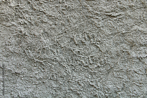 The texture of the stones and cobblestones. Fragment of a gray granite wall.