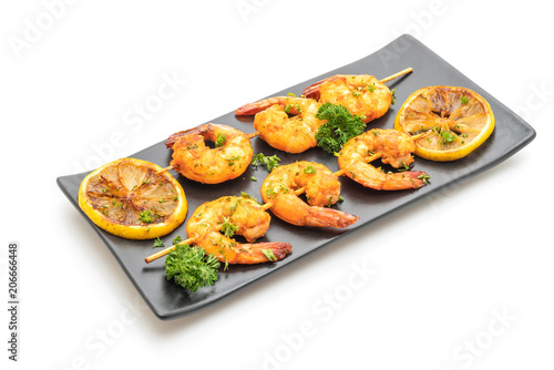 Grilled tiger shrimps skewers with lemon
