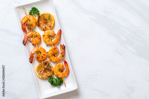 Grilled tiger shrimps skewers with lemon