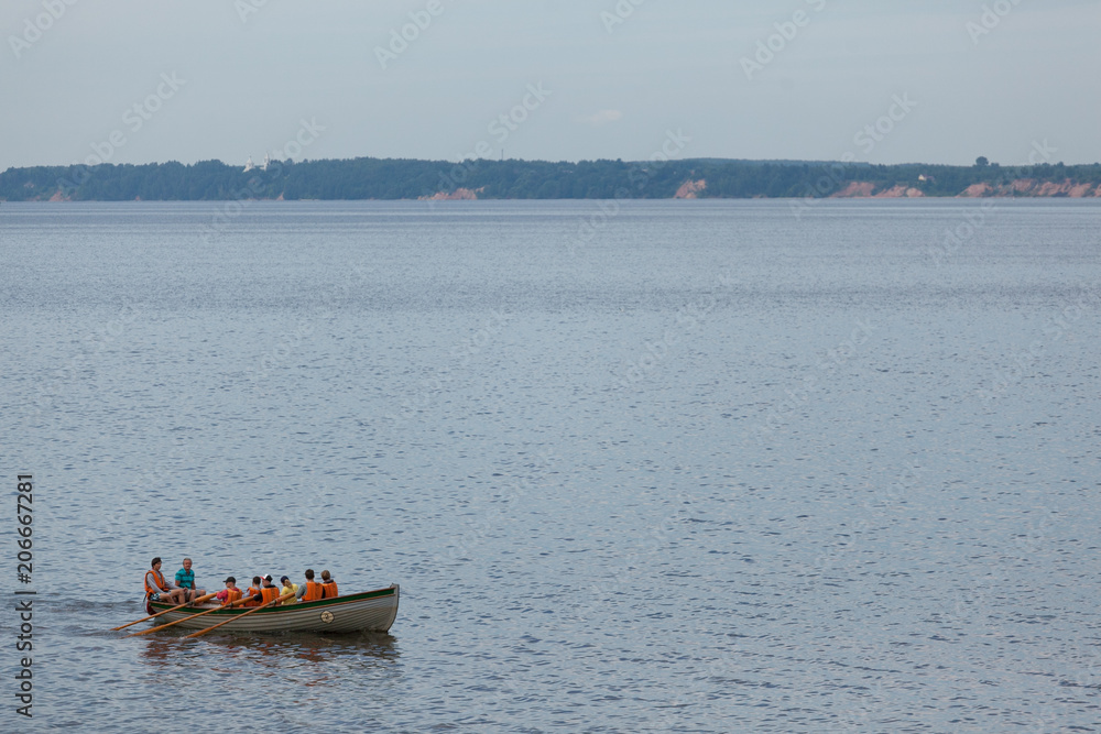 Rowers in lifejackets on a boat sail along the Gorky water reservoir on the Volga River Rowers in lifejackets on a boat sail along the Gorky water reservoir on the Volga River