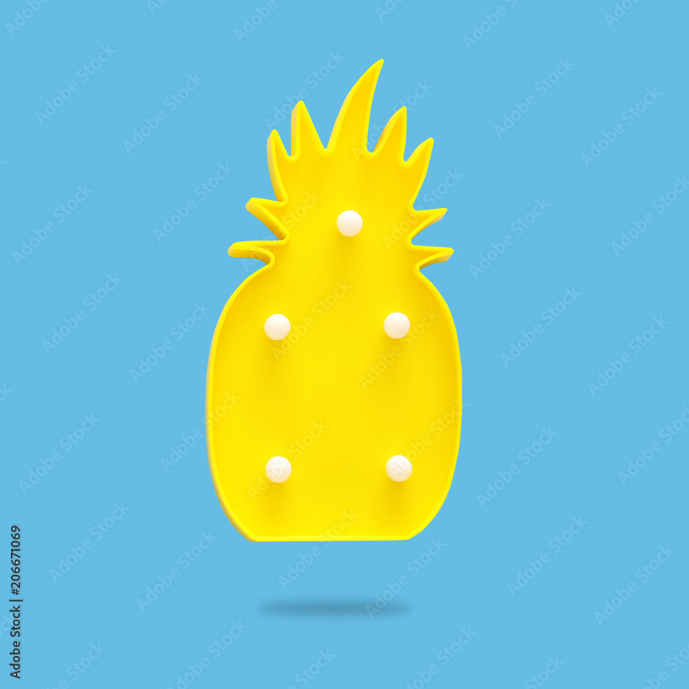 Fototapeta premium a plastic pineapple lamp with leds over blue background. holiday summer concept.