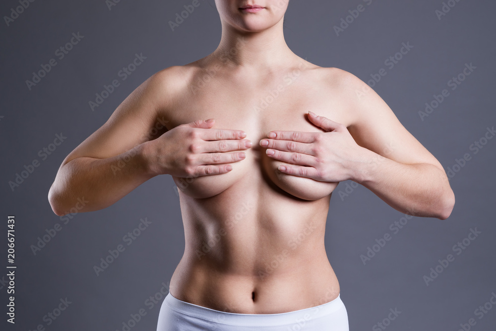 Woman examining her breasts for cancer, pain on female body Woman examining her breasts for cancer, pain on female body