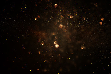 glitter vintage lights background. dark gold and black. de focused.