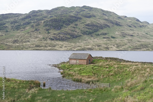 Scottish croft ancient lonely single one traditional home on island by loch mountain background green landscape highlands uk