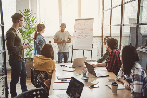 Concentrated man demonstrating presentation on board while talking with partners during job