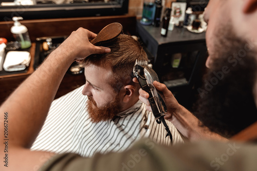 Barber and bearded man in barber shop