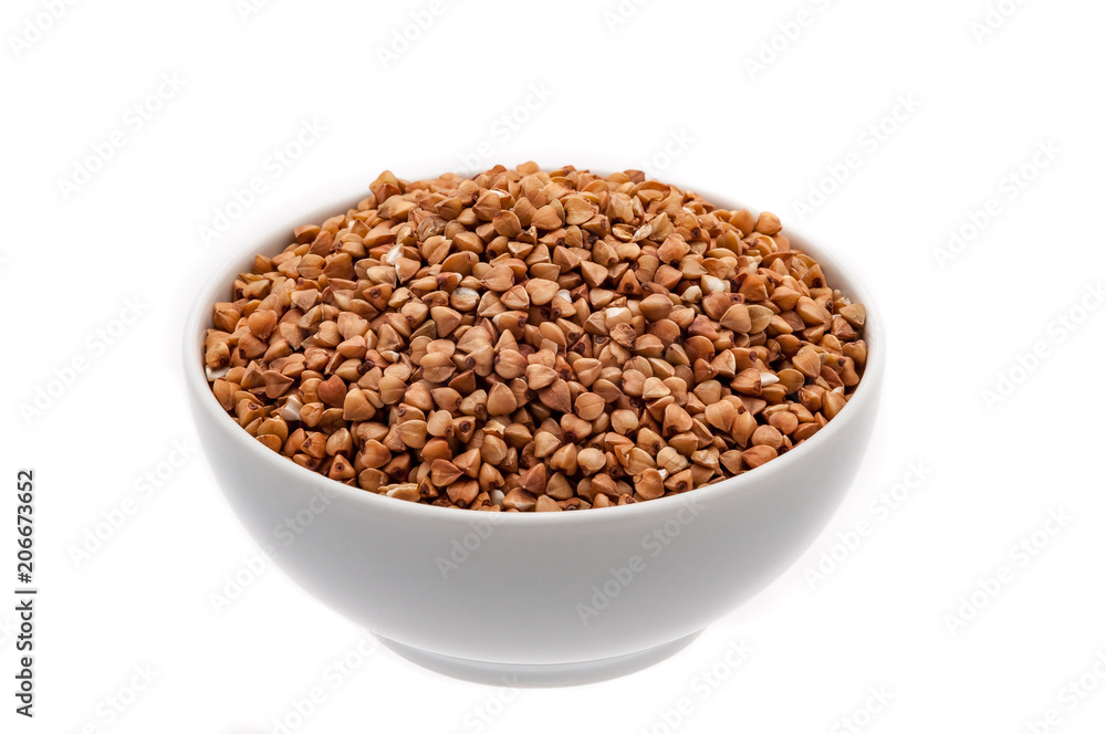 Buckwheat groats in a white cup close-up on a white background. Isolated. Buckwheat groats in a white cup close-up on a white background. Isolated.