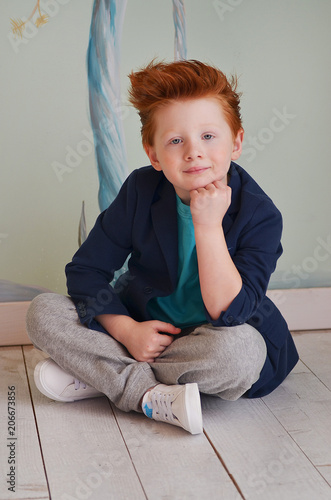 Portrait of cute red haired boy in the studio. Kids with unusual appearance. Handsome children.