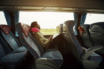 Portrait of smiling man using laptop computer in bus travel