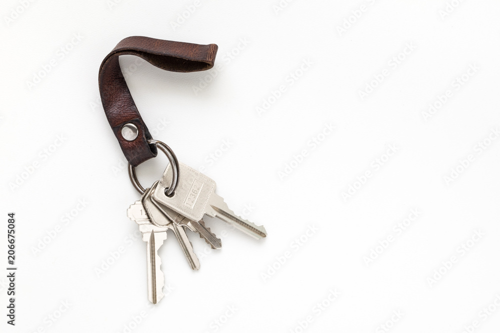Keys attached to leather keychain on white background Keys attached to leather keychain on white background
