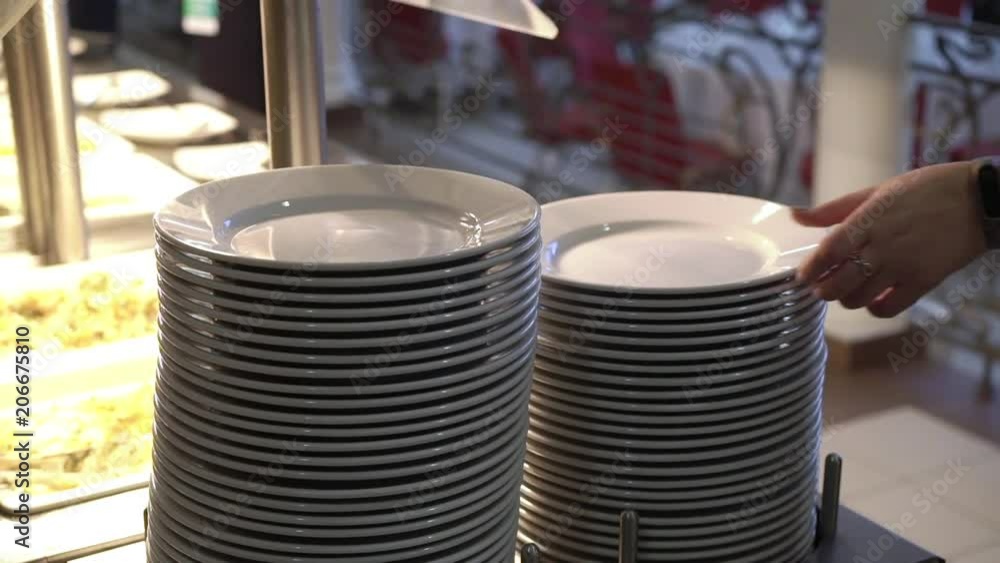 Woman takes plate at buffet closeup Woman takes plate at buffet closeup