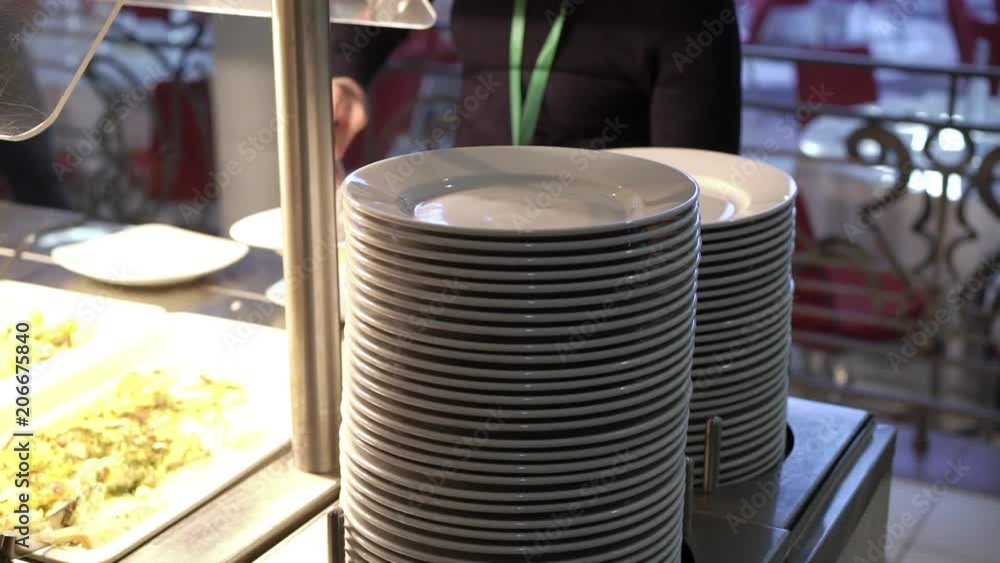 Woman takes plate at buffet closeup Woman takes plate at buffet closeup
