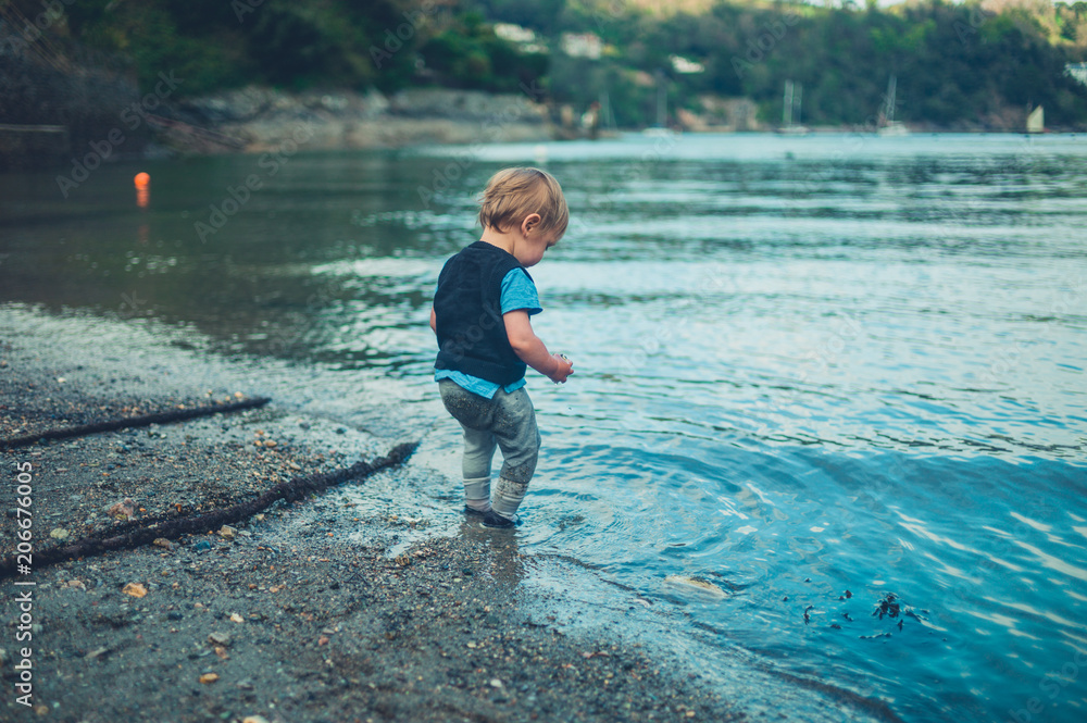 Toddler boy playing by the water Toddler boy playing by the water