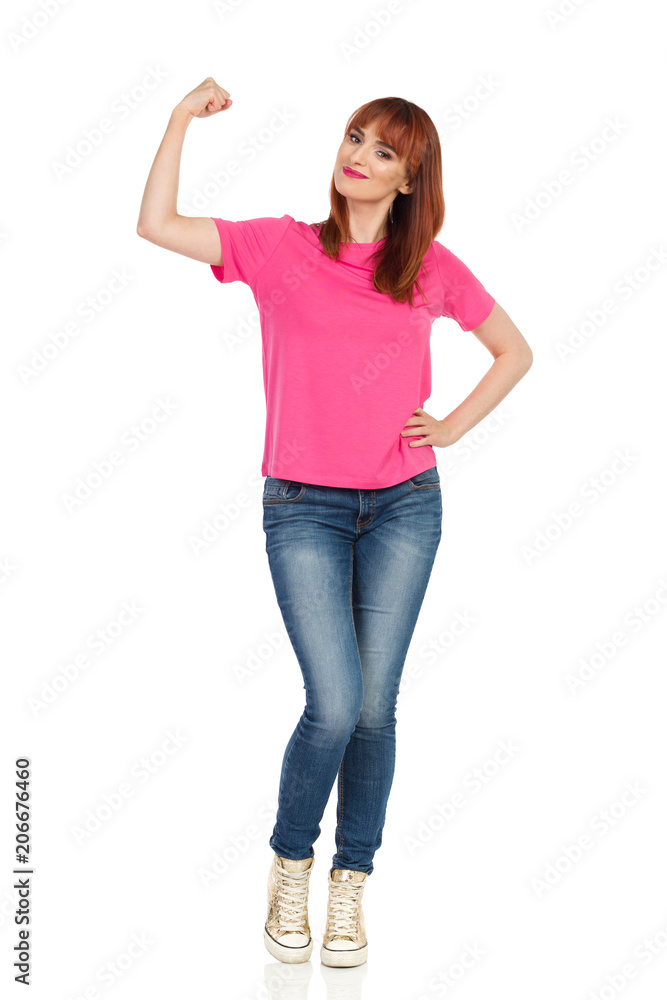 Smiling Young Woman Is Flexing Muscles And Looking At Camera Smiling Young Woman Is Flexing Muscles And Looking At Camera