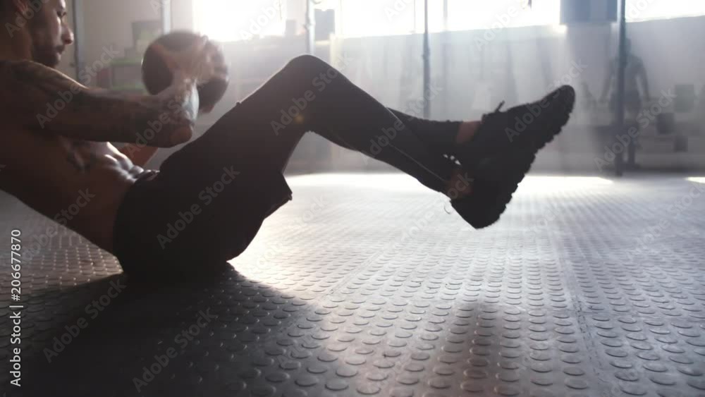 Footage of a fitness man exercising with medicine ball at healthclub. Male at gym doing workout with fitness ball.
