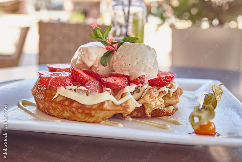 waffles with white chocolate sauce, ice cream and strawberries waffles with white chocolate sauce, ice cream and strawberries