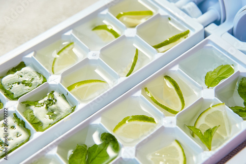 Ice cubes with green mint leaves and lime