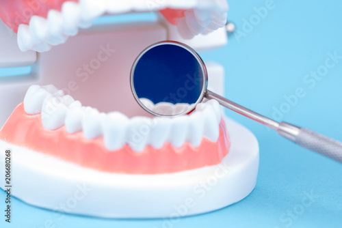 Zahnersatz mit einem Zahnarzt Spiegel bei einer Untersuchung