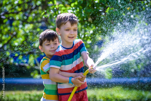 Brothers having fun splash each other with water in the village