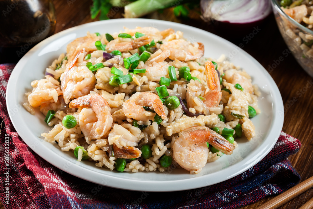 Fried rice with shrimp and vegetables served on a plate Fried rice with shrimp and vegetables served on a plate