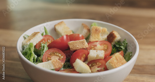 closeup adding croutons to caesar salad photo