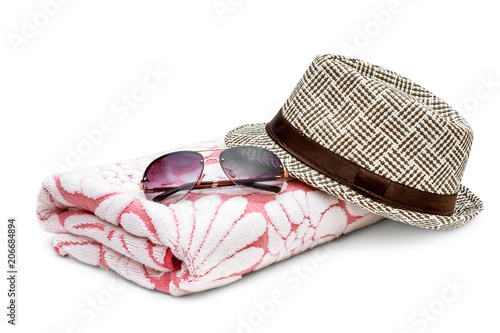 Sunglasses with summer hat and towel on white.