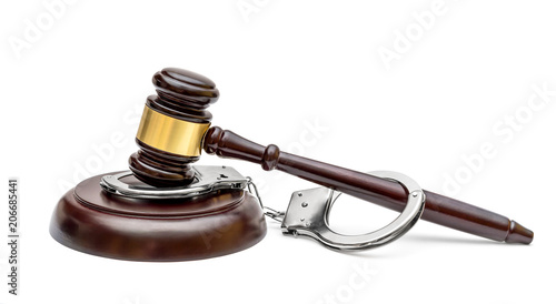 Gavel with stand and handcuffs on white background.