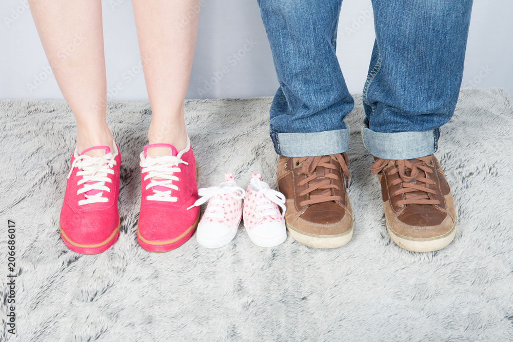 mother father and baby feet with shoes for family concept foot newborn girl
