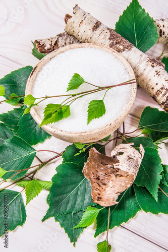 Xylitol - sugar substitute. Birch sugar on white wooden background.